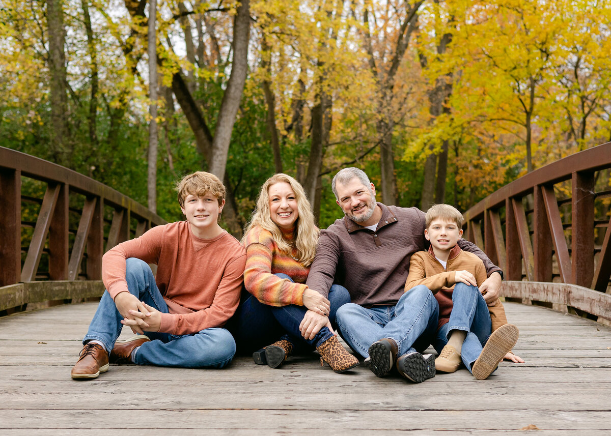 Family sitting on bridge together