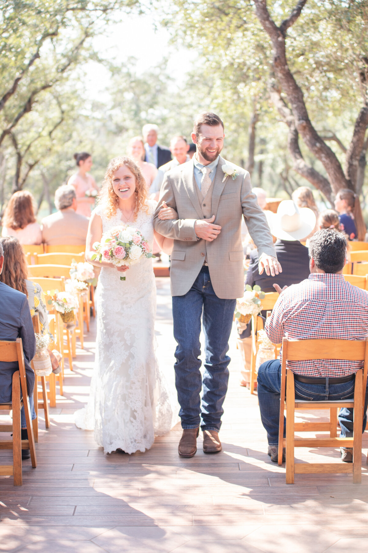 bride with lace wedding dress and groom in jeans and boots  by Texas wedding photographer Firefly Photography