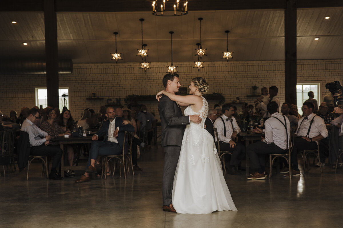 A newlywed couple shares their first dance as husband and wife while surrounded by guests at their wedding reception taken by jen Jarmuzek photography a Minneapolis wedding photographer