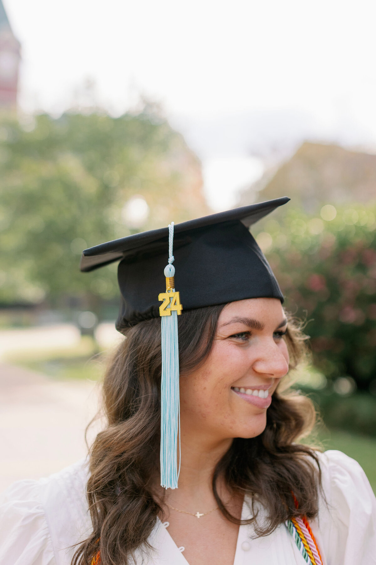 2024 Graduate Cap with a smiling graduate