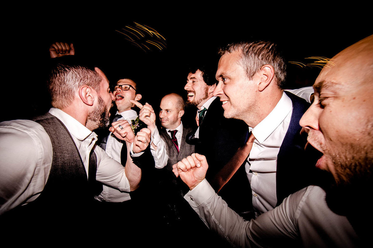 the groom and ushers dancing at the evening of a barn wedding at lowlands in the lake district