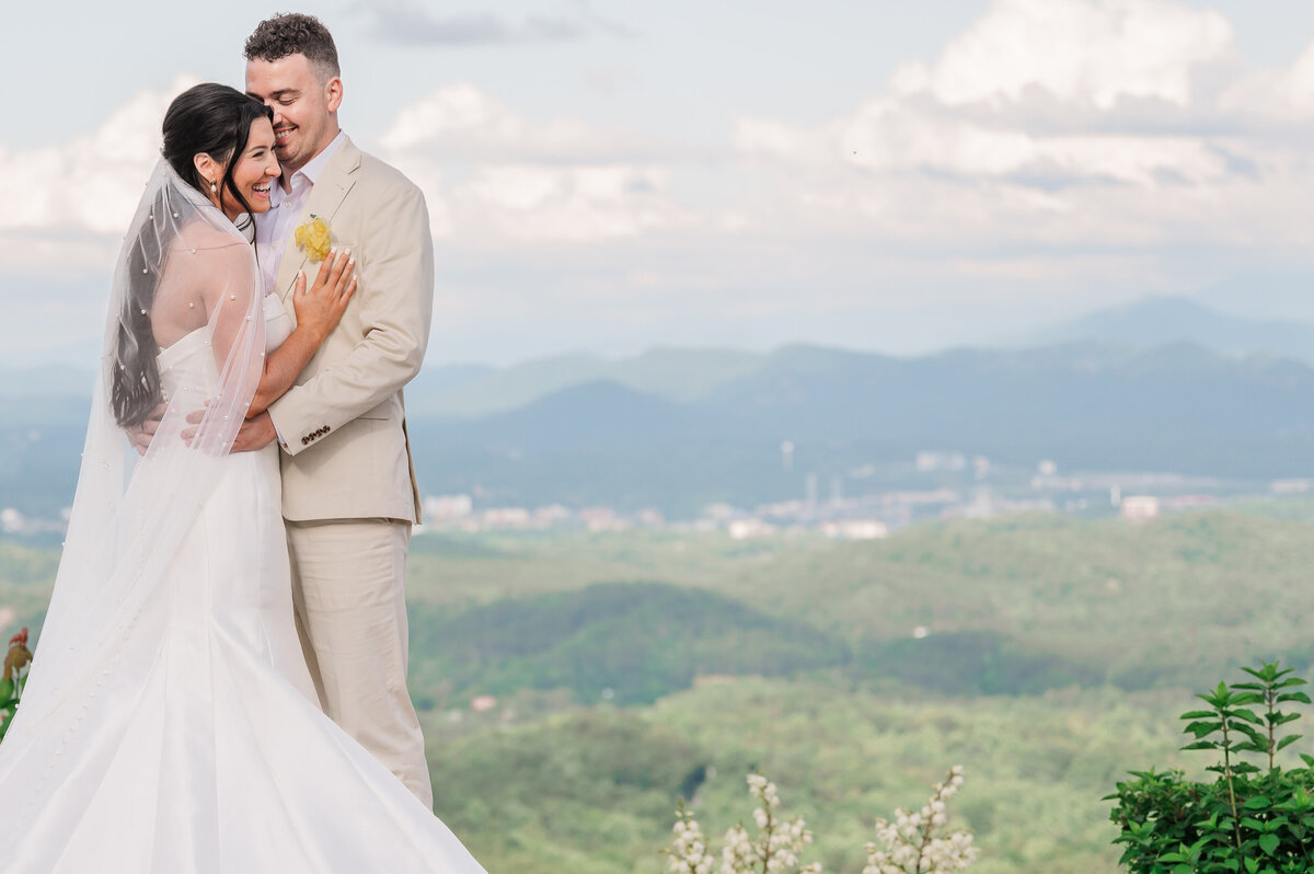A couple embracing on the edge of the Sevierville Mountains during the summertime by Raleigh wedding photographer, JoLynn Photography