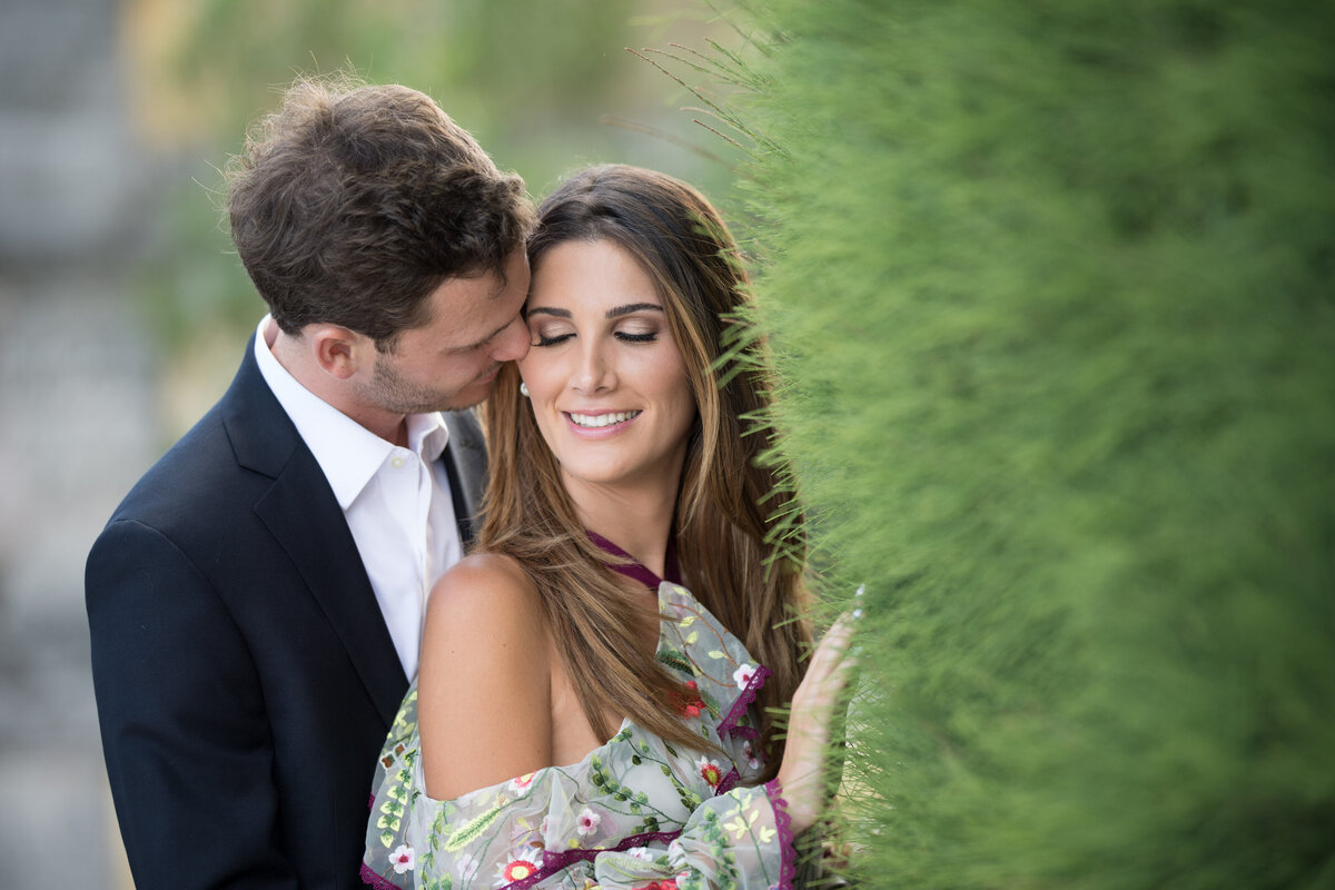 Engagement photo of a couple embracing in a lush green garden, captured by Rodrigo Varela Photography in Miami, Florida. Natural and intimate portrait highlighting romance and scenic beauty.