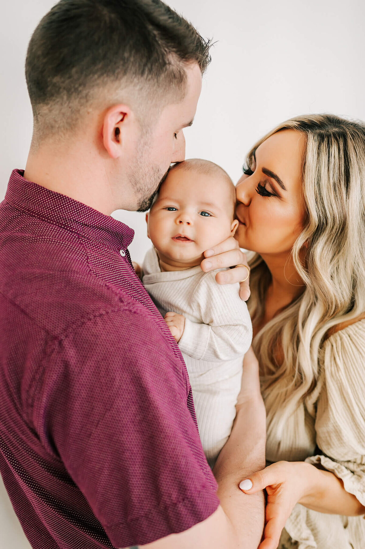 Springfield MO family photographer The XO Photography captures parents kissing baby boy on forehead