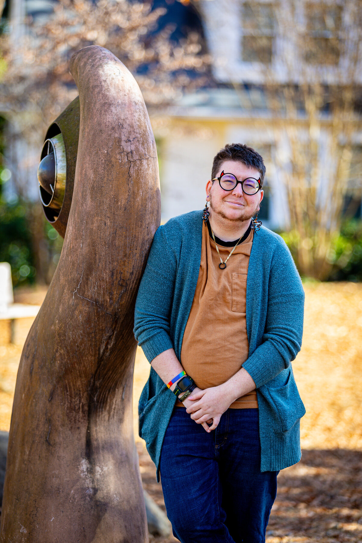 A person leaning against a sculpture in a park.