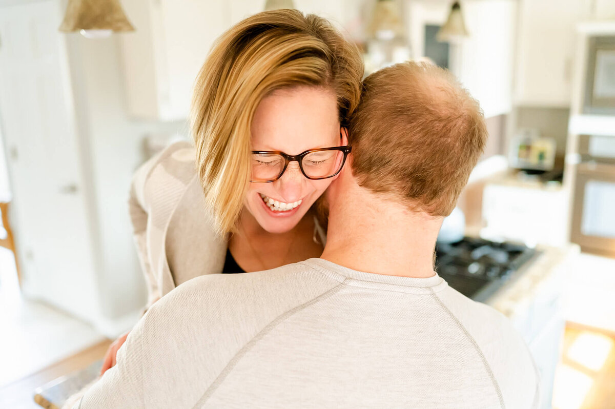 Man tickling woman in kitchen during a couples photography session near Naperville, IL.