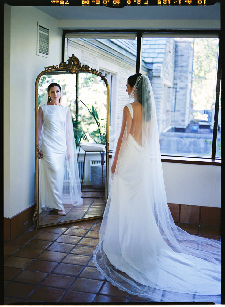 Bride looks at herself from the mirror when getting ready at The Estates of Sunnybrook