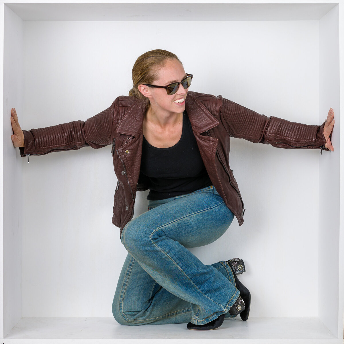 Headshot and branding photographer Jen from Fox & Brazen in  a white box wearing a leather jacket
