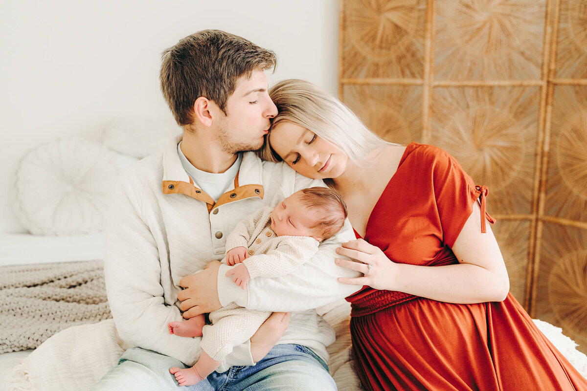 mom and dad snuggle and hold their baby at newborn session in jackson missouri