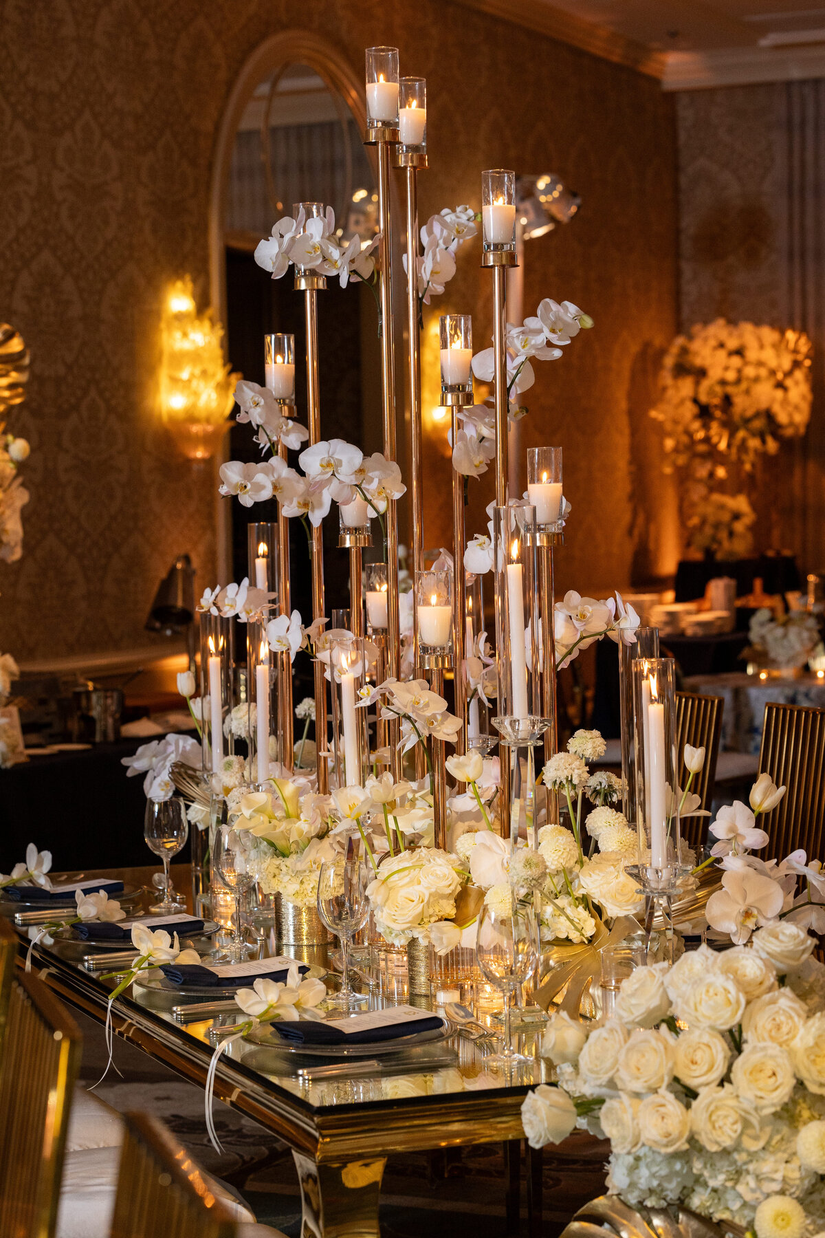 Side golden dinneing table with long candles and white Orquids