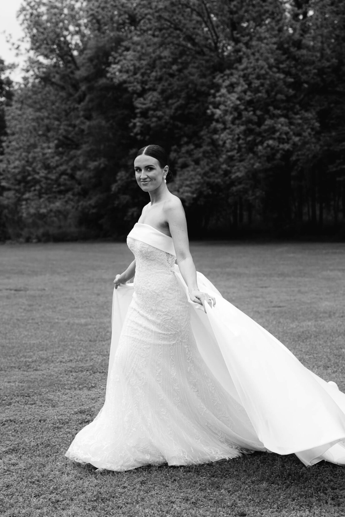 A black and white wedding day photo of the bride in her white dress