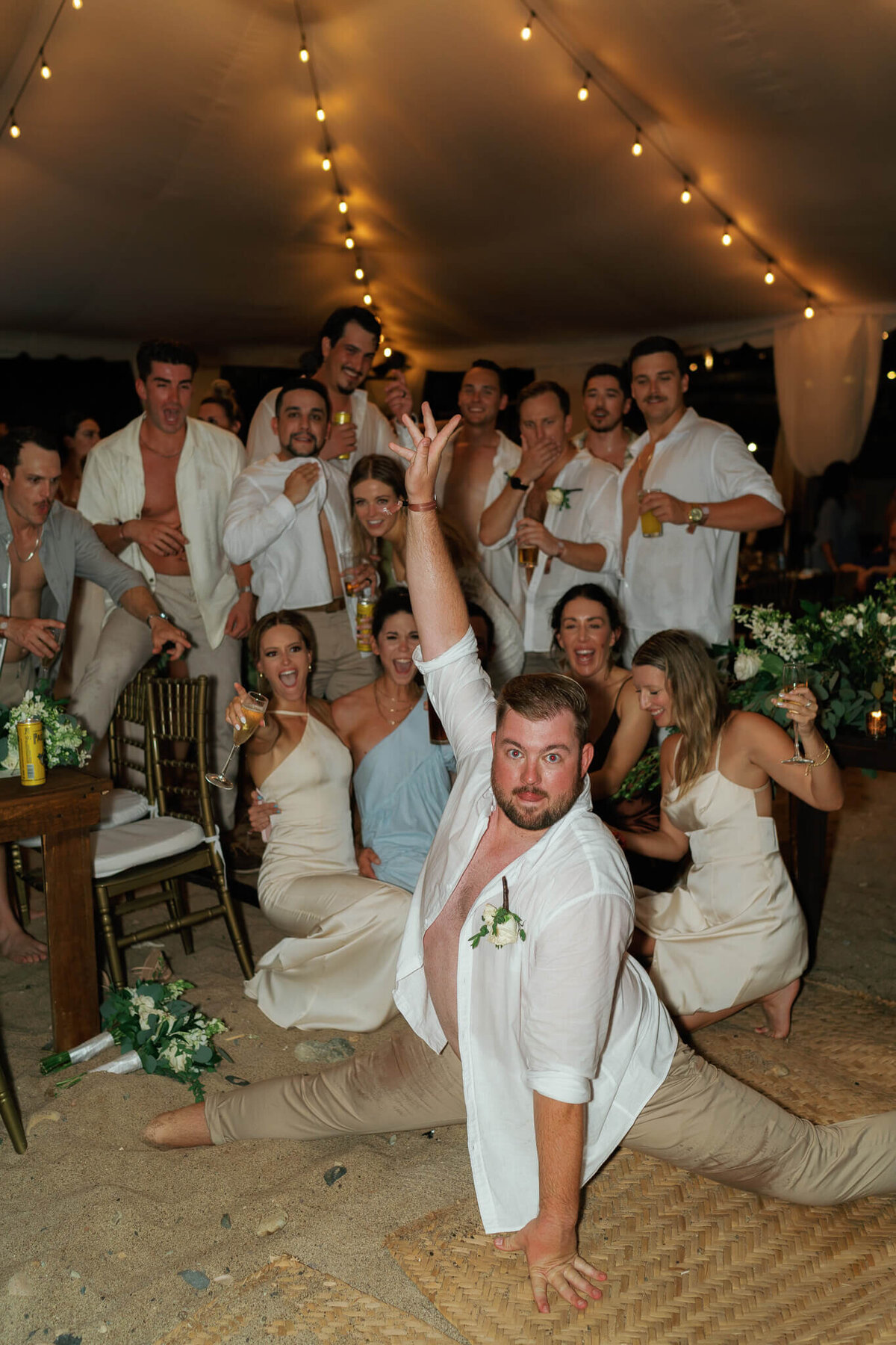 bridal party celebrating in mexico, one groomsman is doing the splits