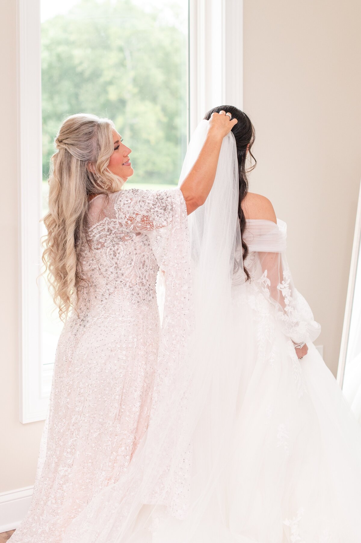 mom placing veil on daughter