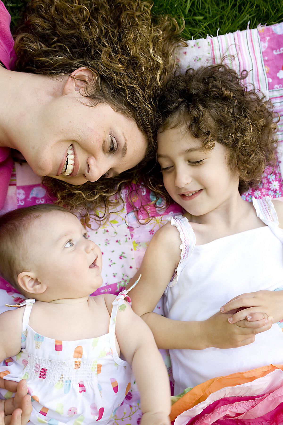 A parent laying down with their two children 