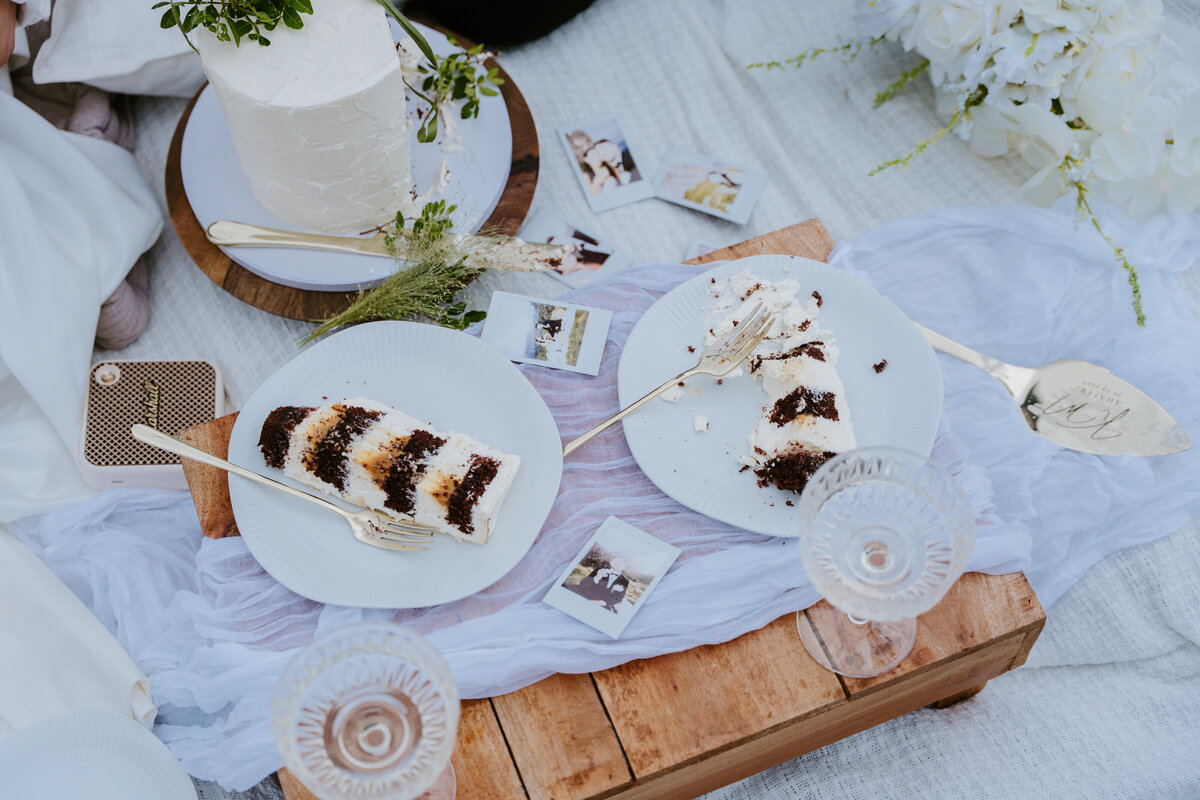 Couple laughing together while sharing cake.