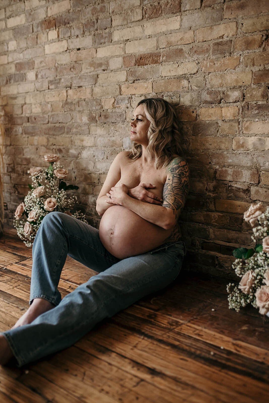 Pregnant-woman-sitting-against-stone-wall