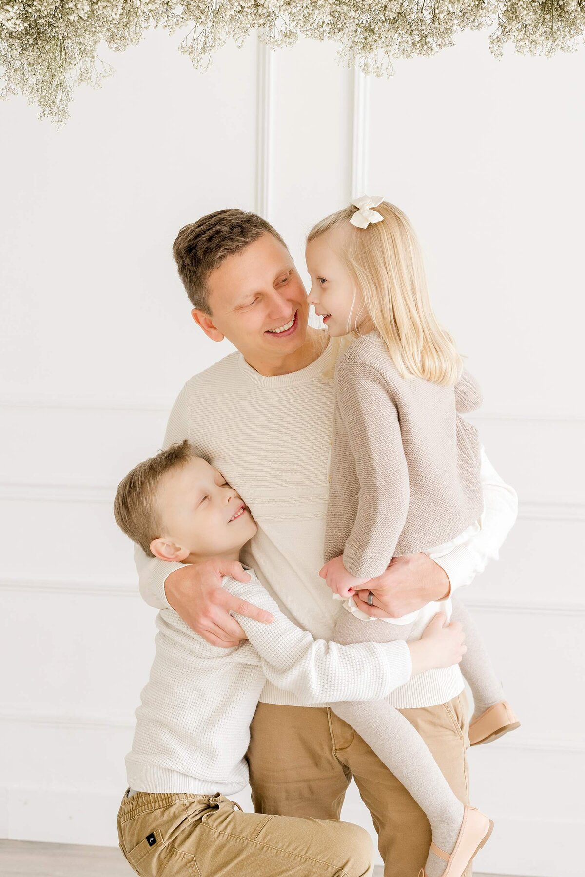 Dad plays with his son and daughter during newborn photo session