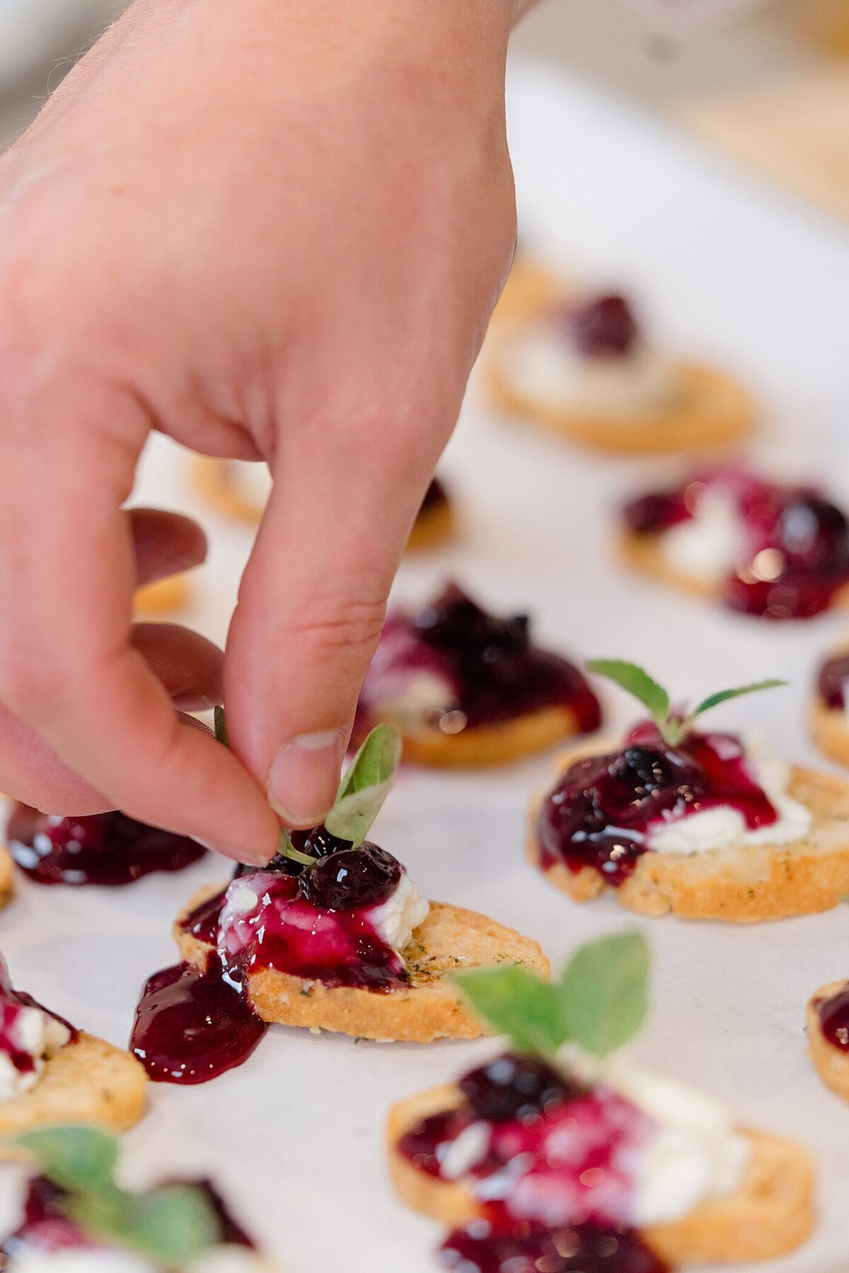Columbus photographer captures brand photos for a catering company with person garnishing a small appetizer