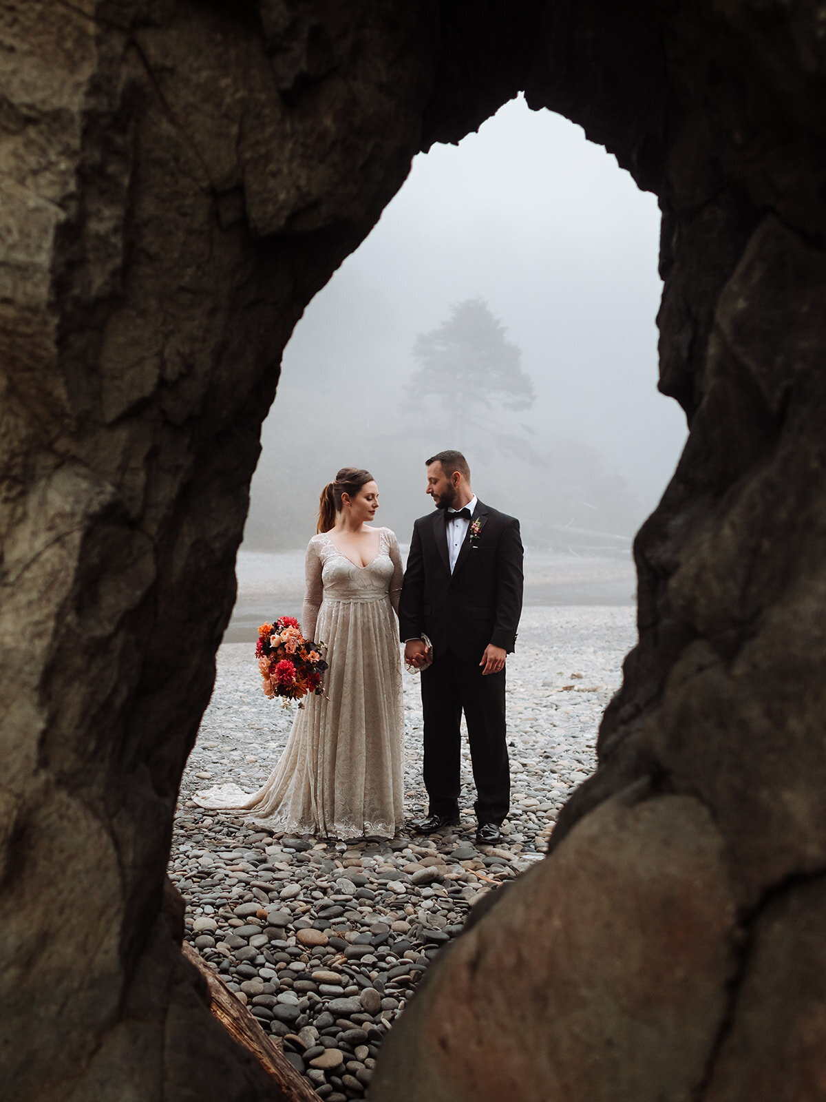 Hole in sea stack framing bride & groom on foggy Ruby Beach in Olympic National Park!