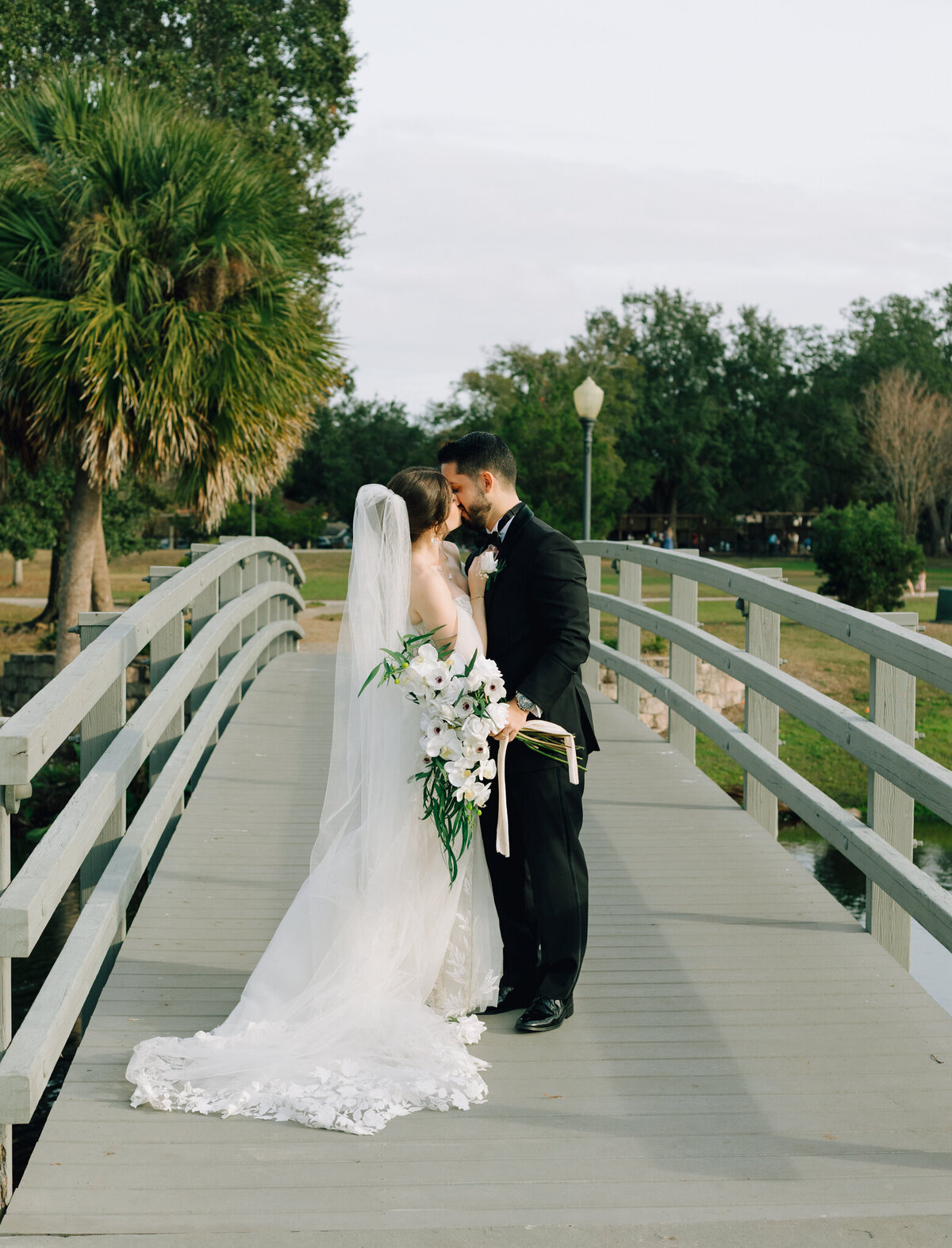 A newly married couple kisses on a North Georgia bridge.