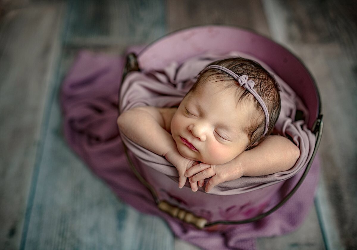 newborn-girl-inside-purple-bucket