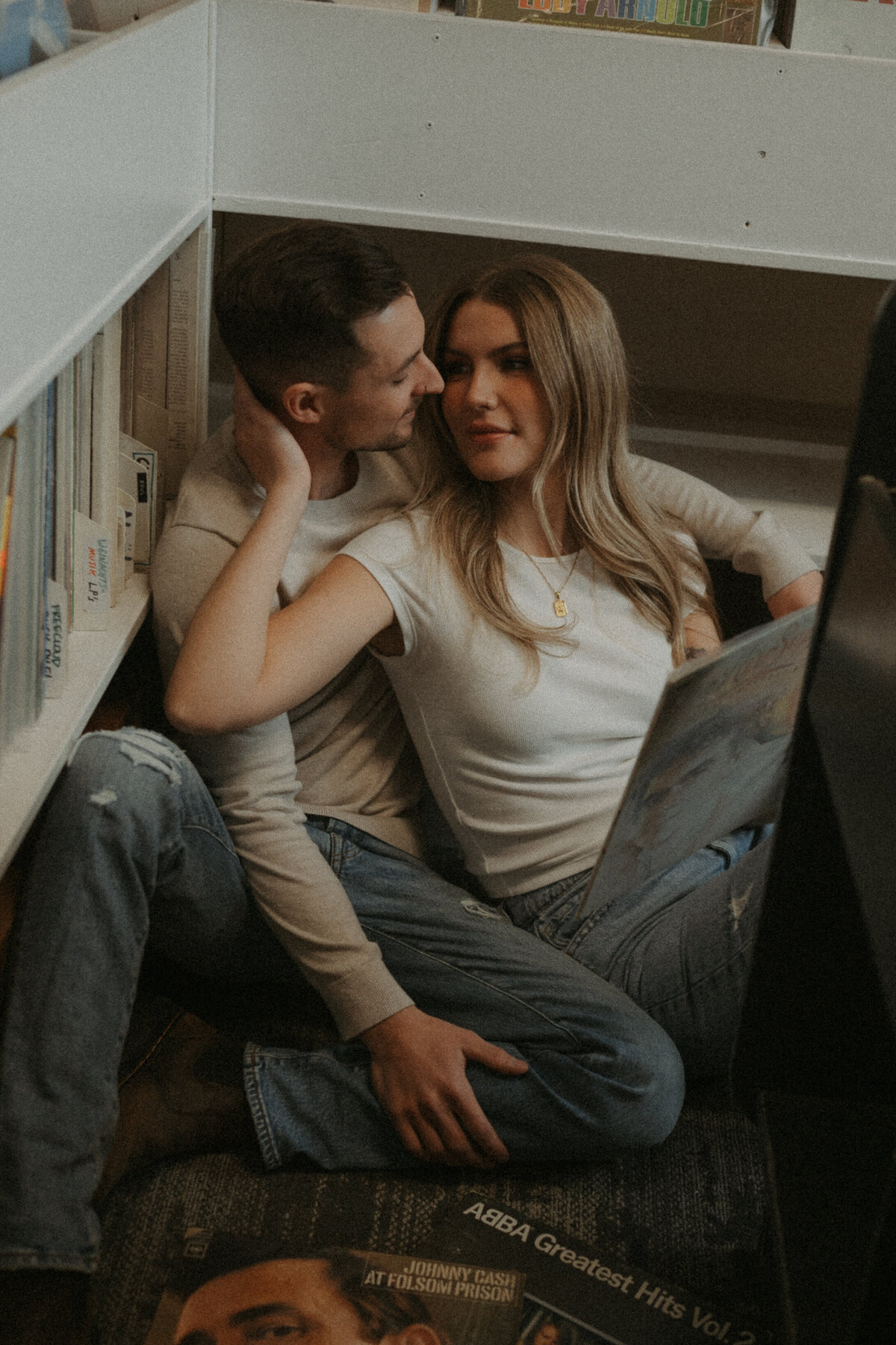 Photo of a couple cozy in the corner of record store 
