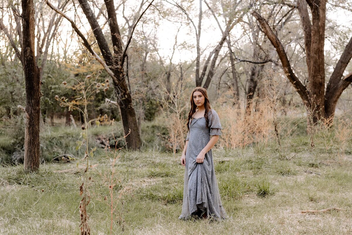 Mary captures a senior girl walking in a field of lush green grass.