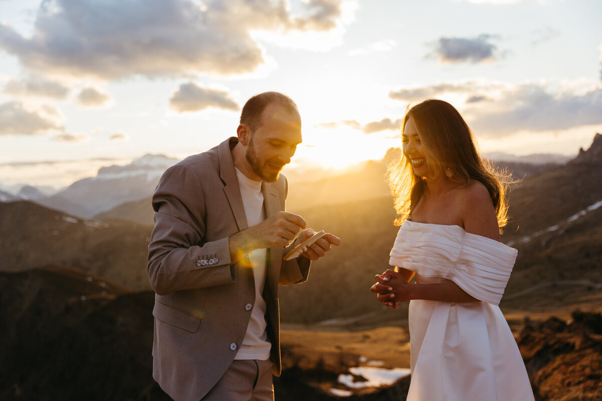 romantic couple wearing wedding ring with dramatic Dolomites backdrop
