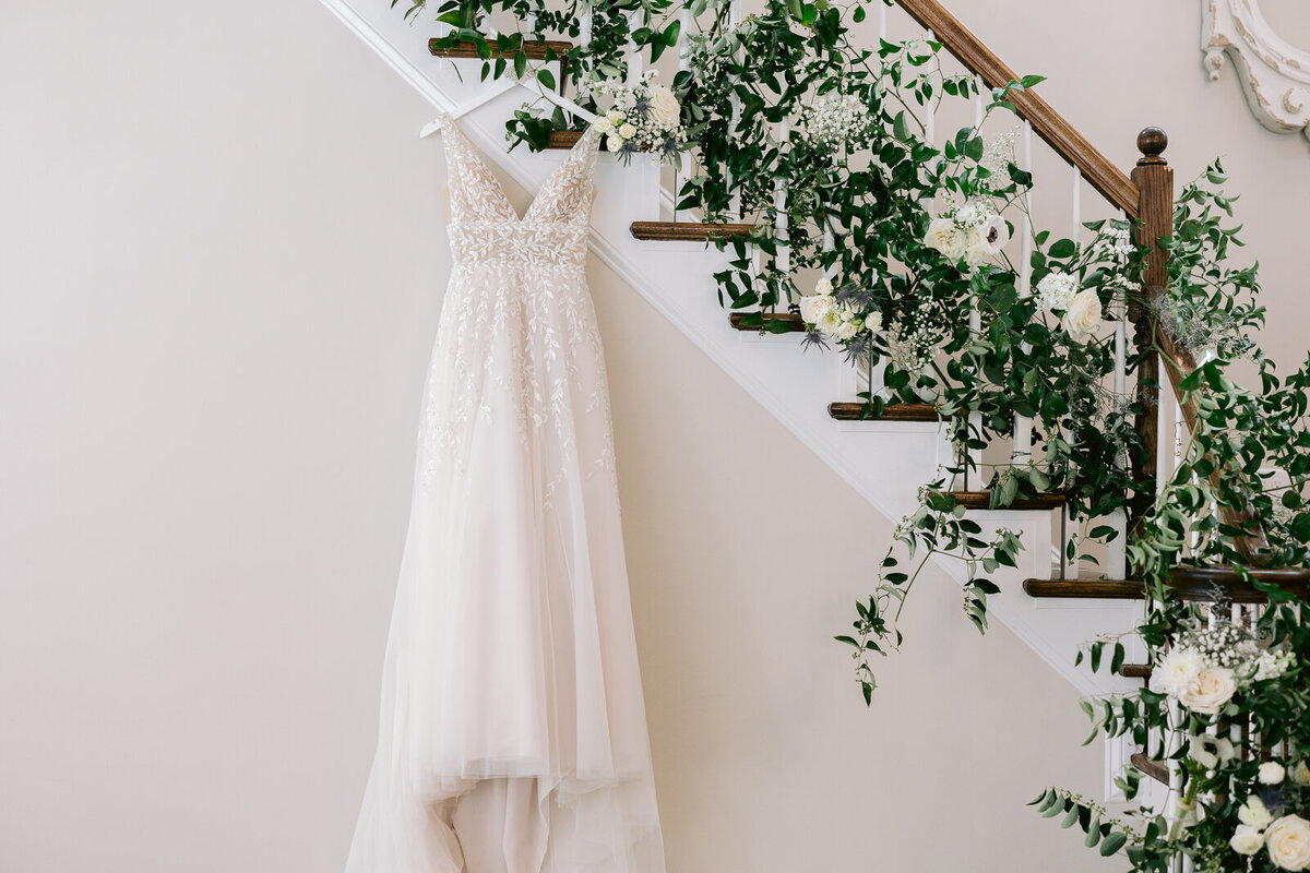 Wedding Photography, a wedding dress hangs on the rail of a staircase