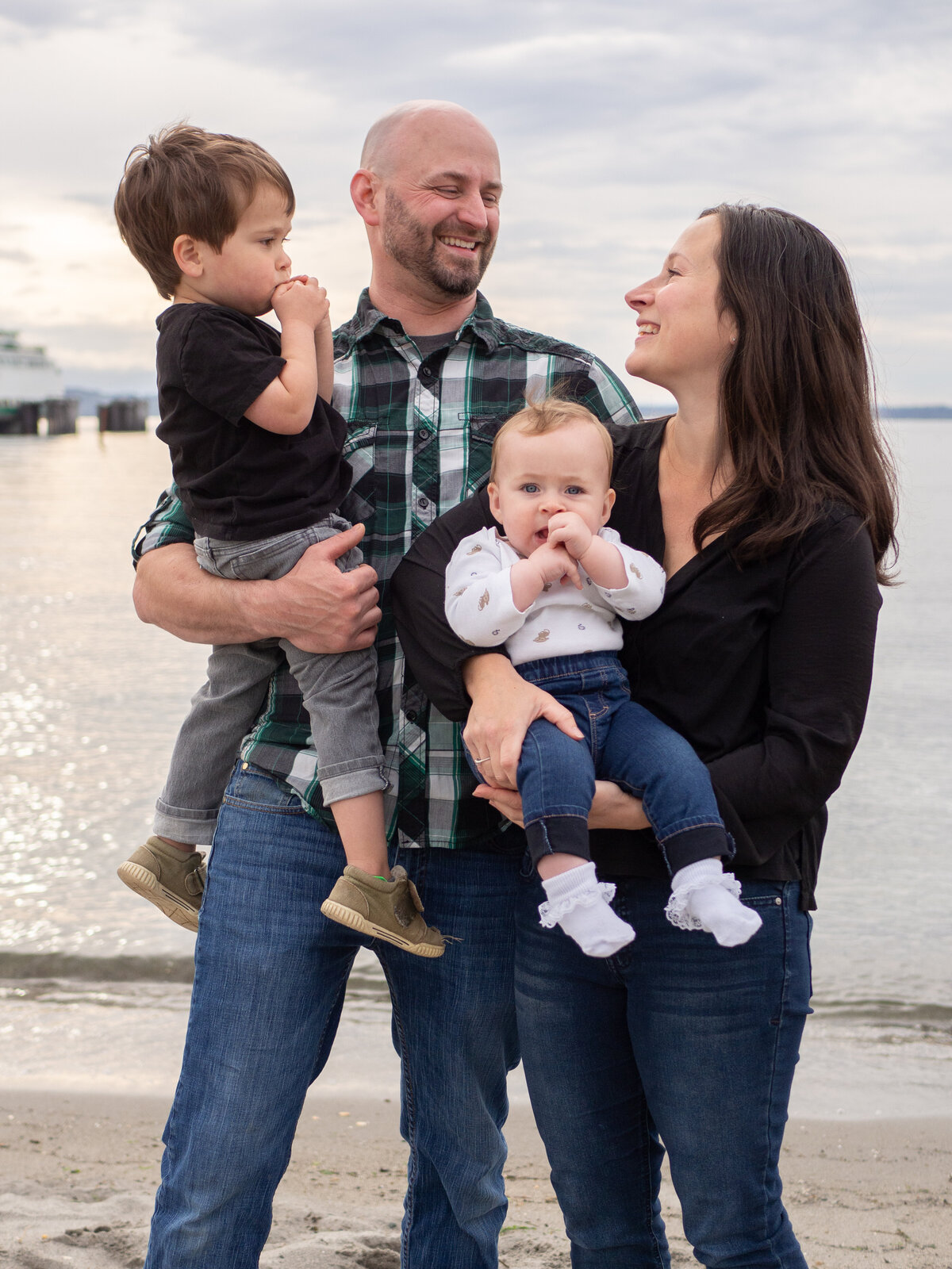 a family of four laugh together at Richmond Beach, WA during a seattle family photo session.