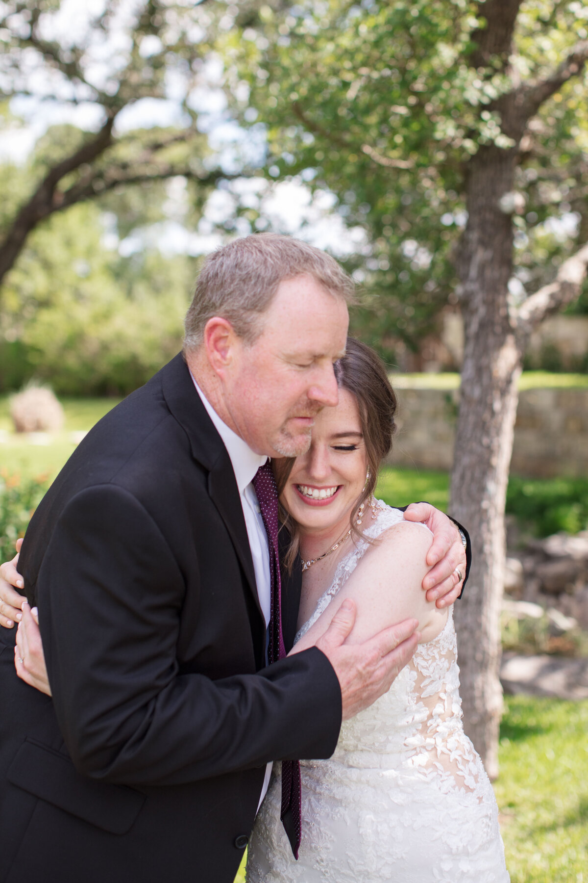 father embraces daughter bride  during first look before Milestone New Braunfels wedding ceremony