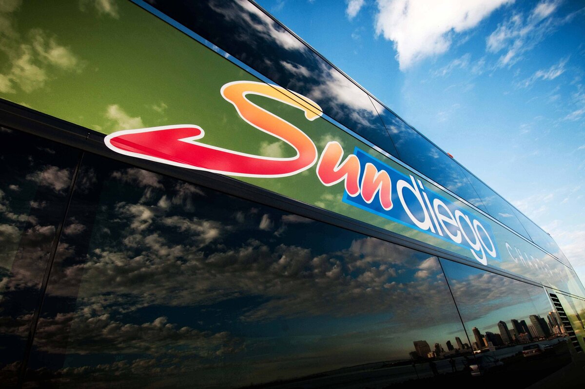 Artistic shot showing the San Diego skyline in the reflection of a Sun Diego Charter Buss window.