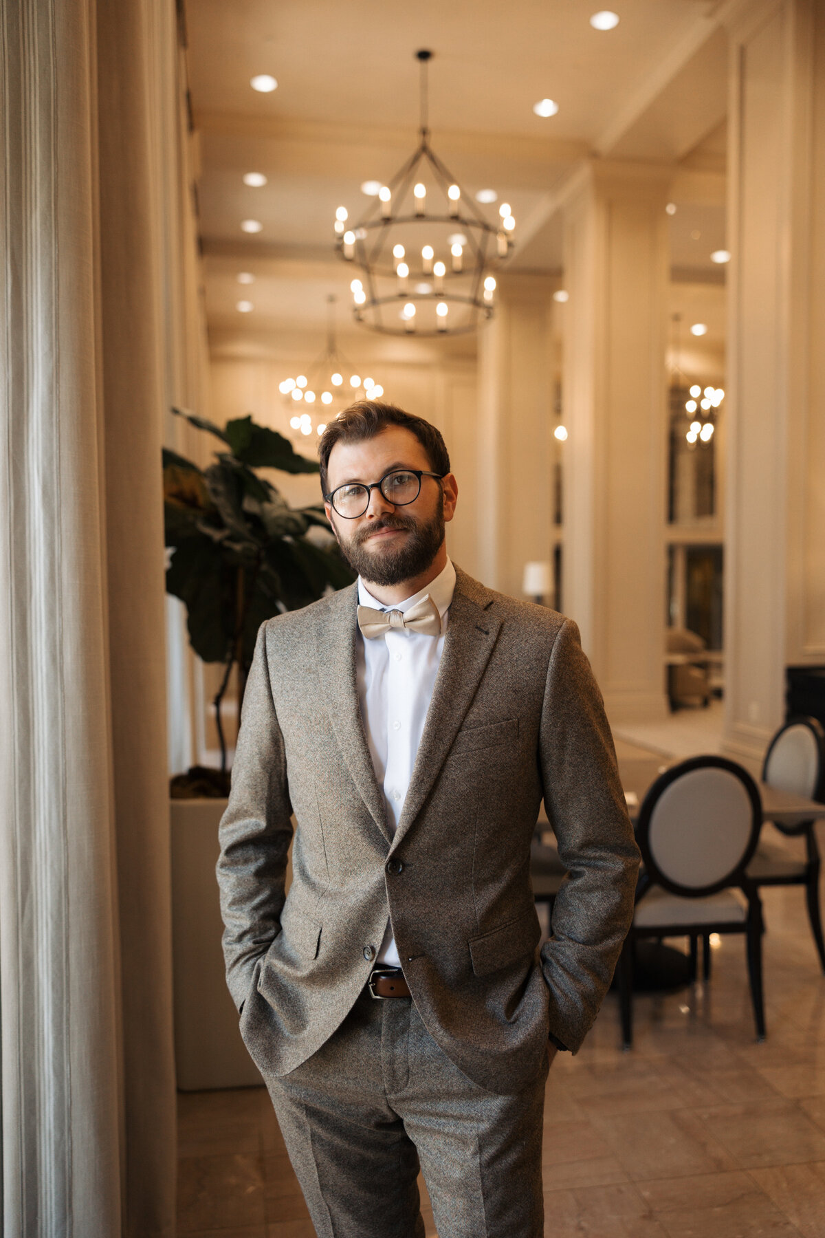 Groom’s portrait in warm indoor lighting at a historic venue.