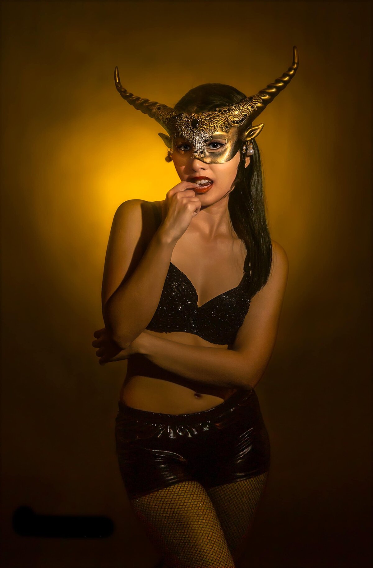 Woman wearing goat mask gold backbround
