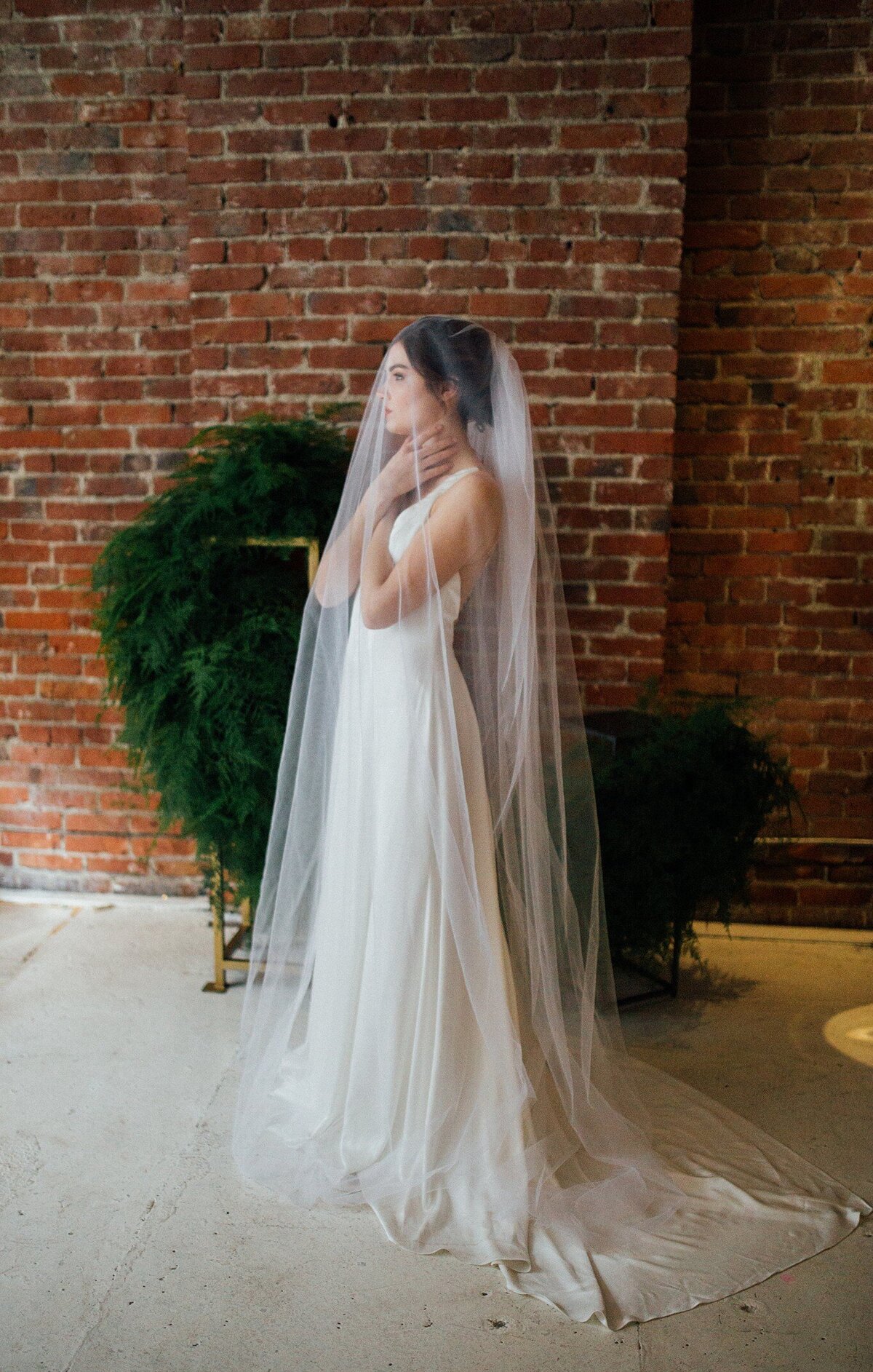 As seen from the side, the sheath silhouette of the Iset bridal style features a column skirt that ends in the back with a pointed train.