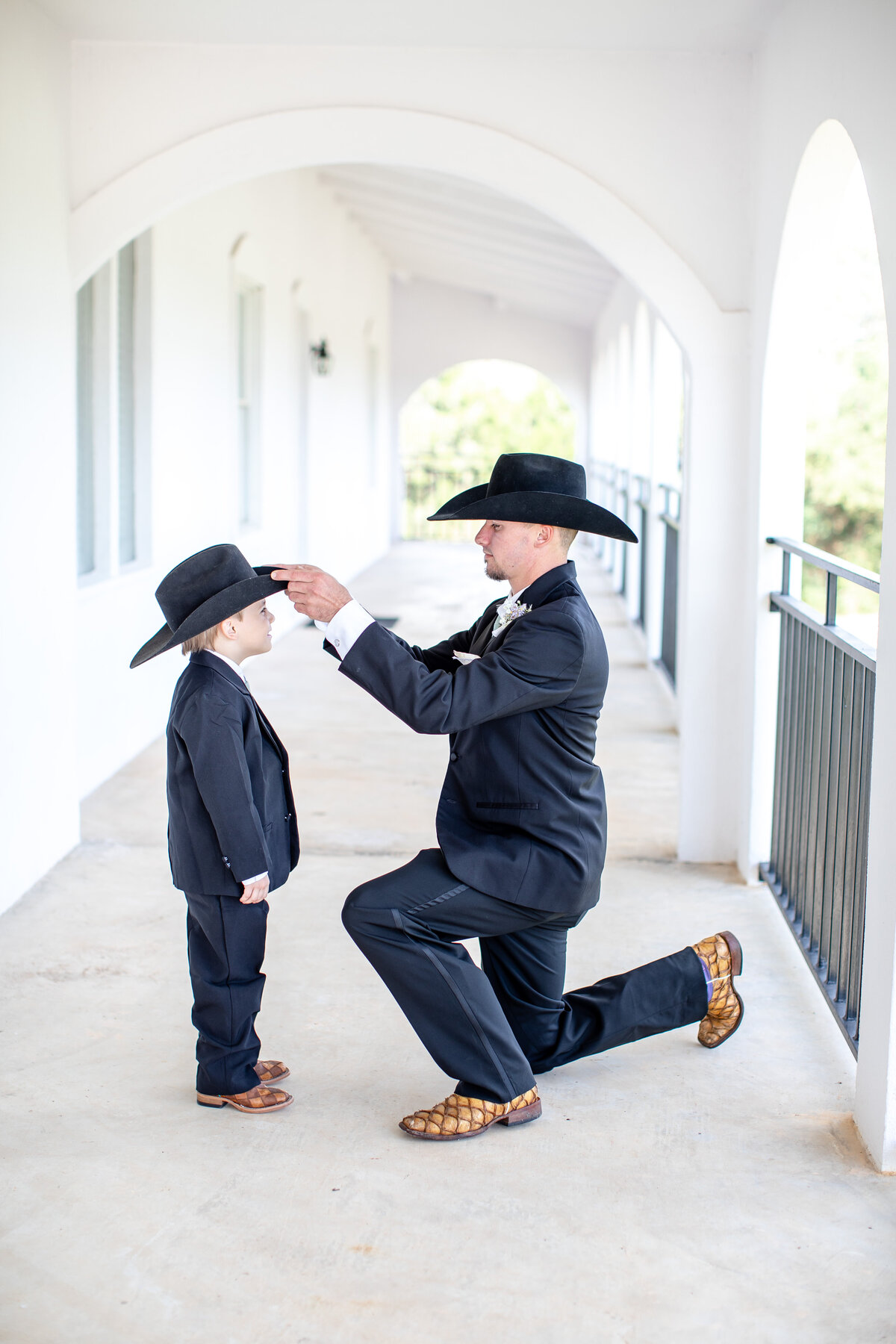 groom adjusts ring bearer's  cowboy hat at La Dolce Vita in New Braunfels Texas