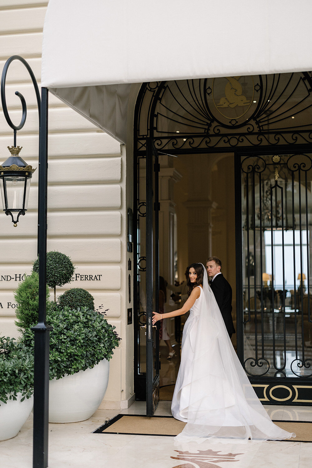 bride and groom walking into grand hotel du cap ferrat on their wedding day