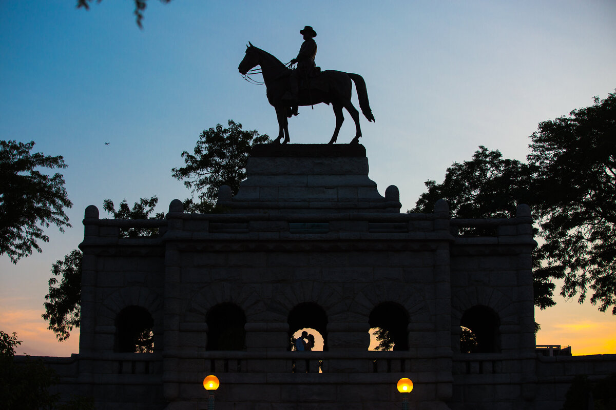 A silhouette of a bride and groom kiss in the sunset at Lincoln park in Chicago.