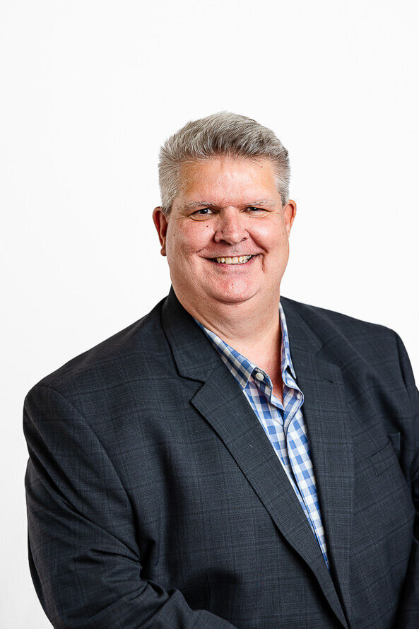 Man smiles for his headshot with Angela Marie Media.
