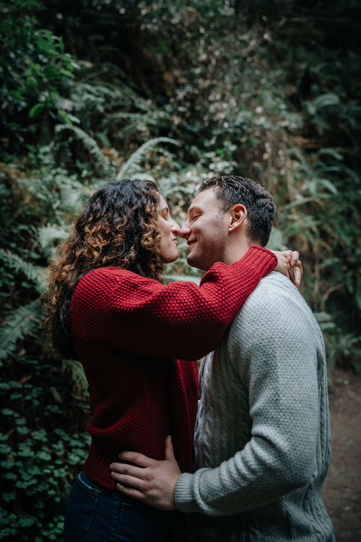 Newly engaged couple kisses in Muir Woods