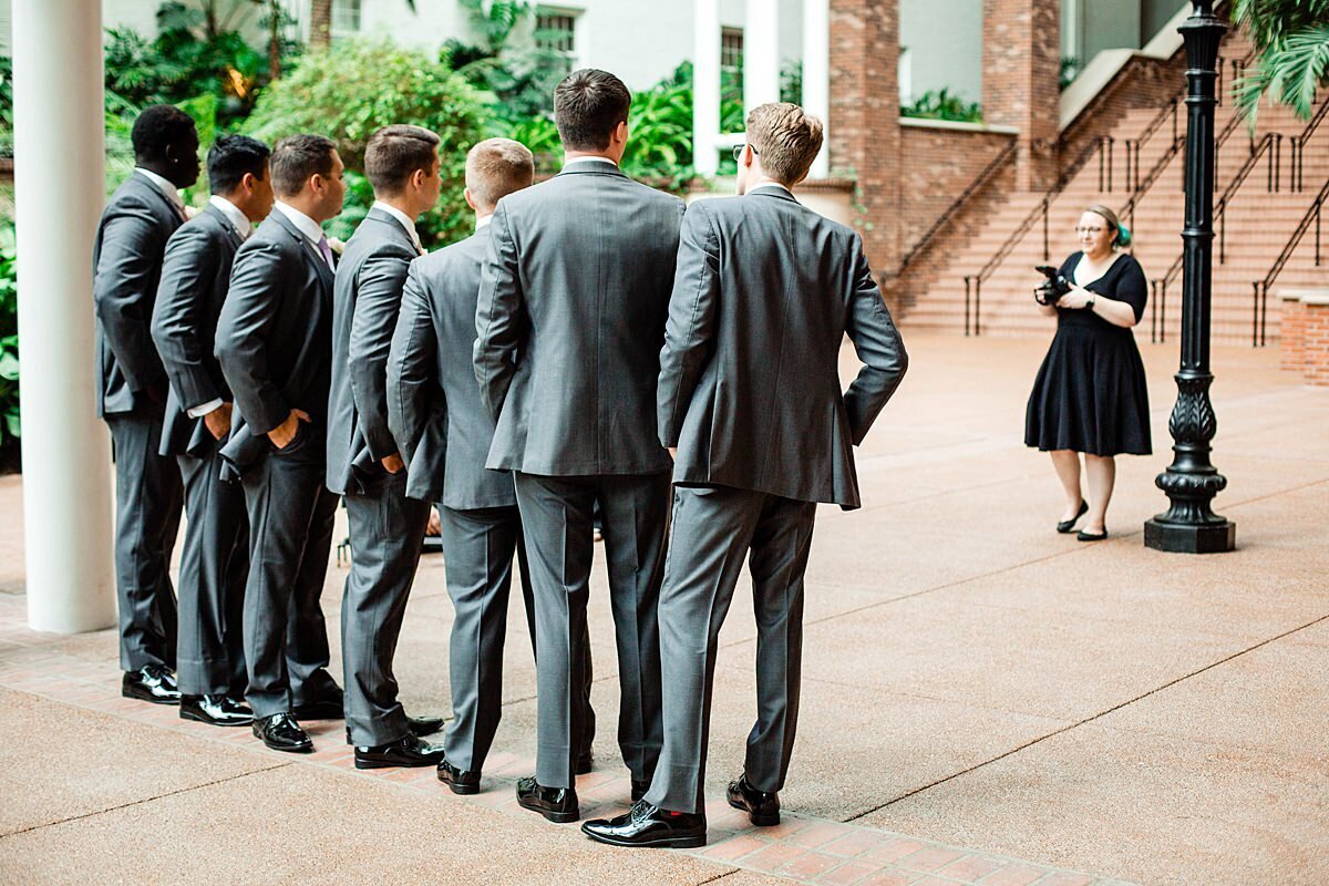 Behind the scenes photo of Mahlia working with groomsmen