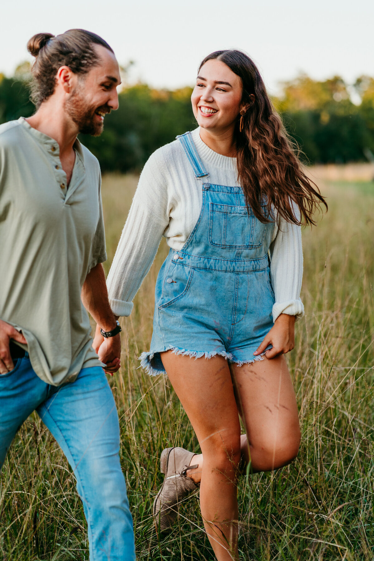 Casual engagement shoot walking through tall grass