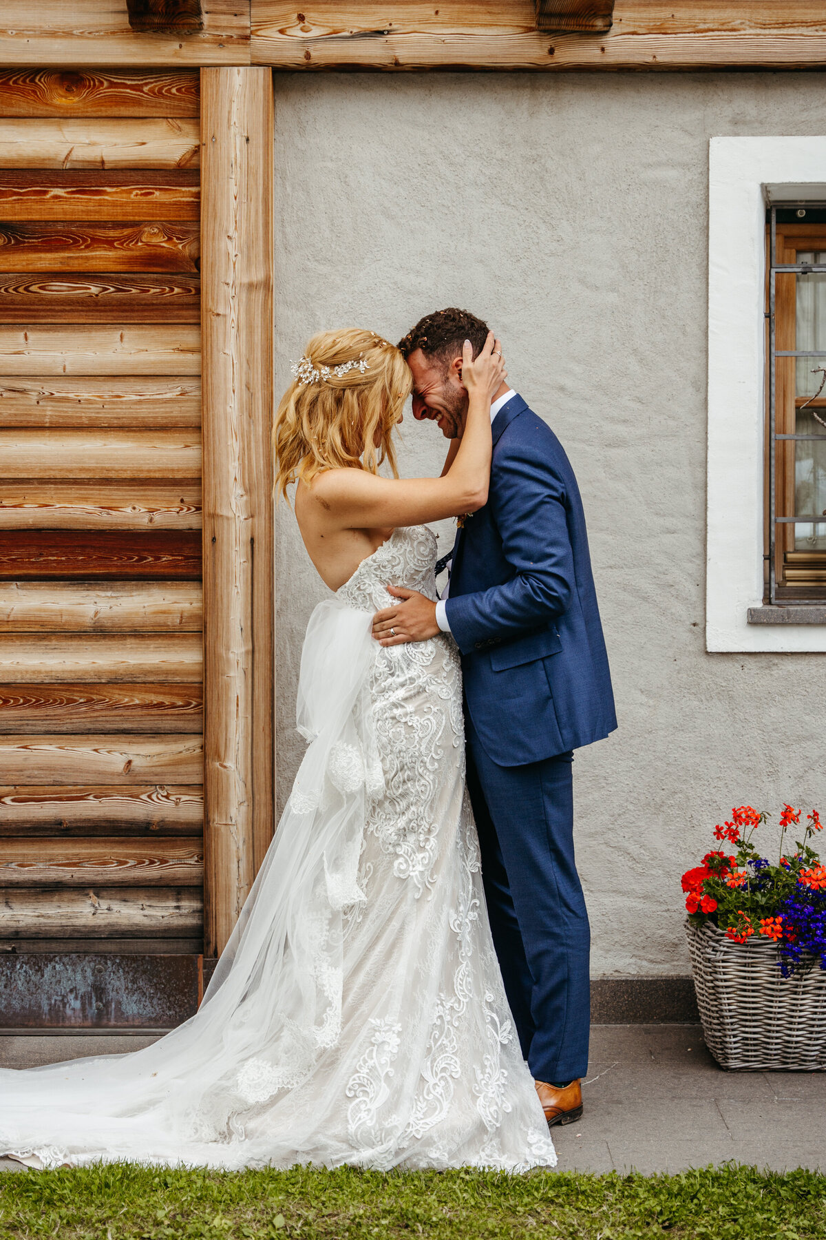 Bride and groom kissing outside rustic lodge Italy