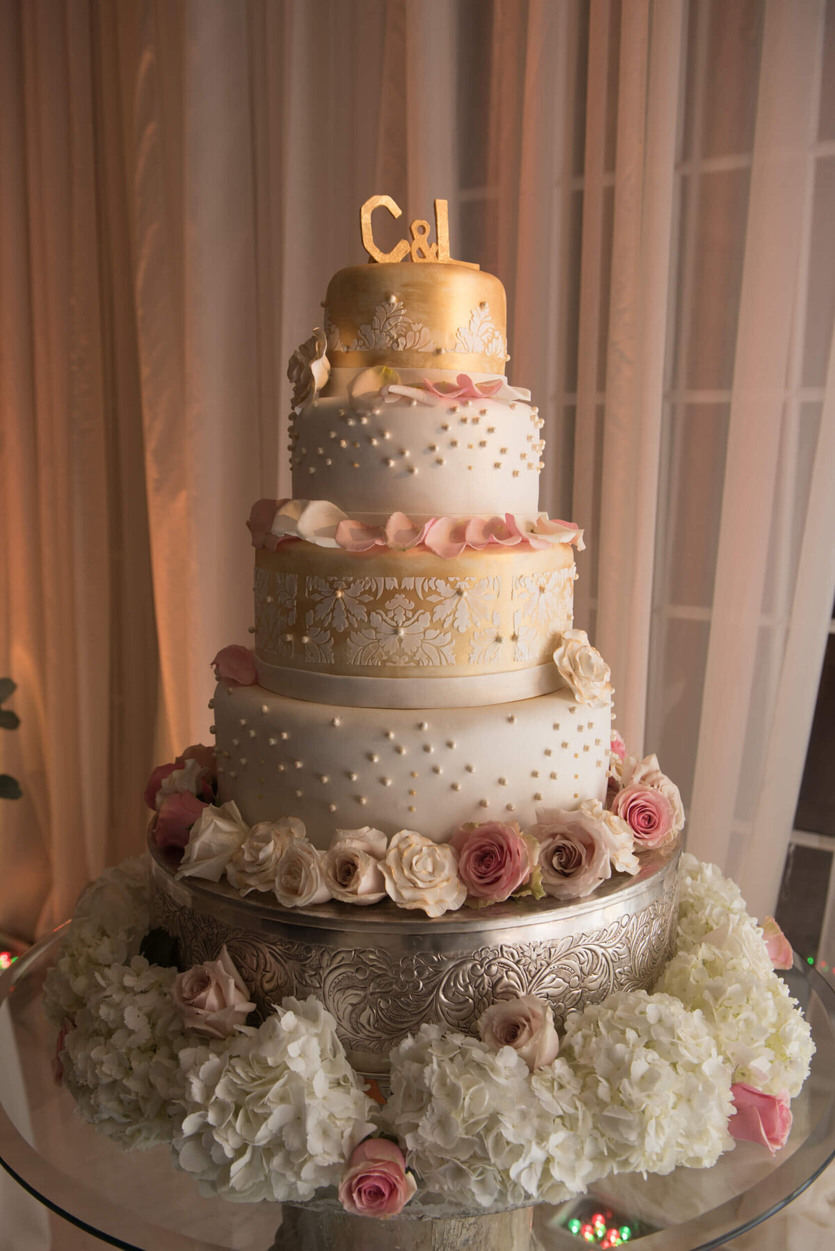 Gorgeous and delicious 4-tiered  wedding cake adorned with fresh flowers