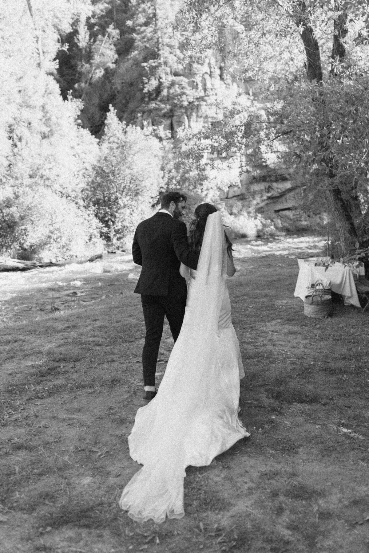 Bride and groom walking through woodland at Dallenbach Ranch Colorado Wedding
