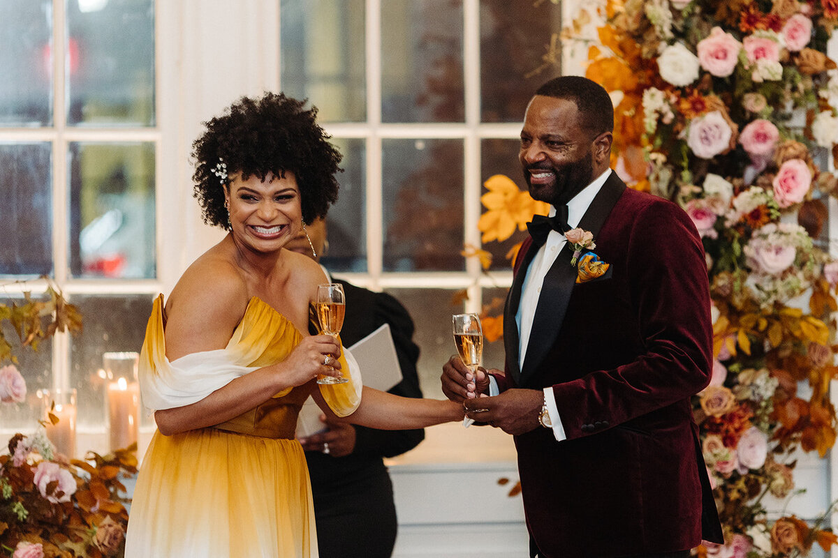 Artful asymmetrical floral wedding ceremony backdrop sets the autumnal hues of mauve, dusty rose, burgundy, terra cotta, and copper florals composed of roses, copper beech, delphinium, raintree pods, mums, and fall foliage. Design by Rosemary and Finch in Nashville, TN.