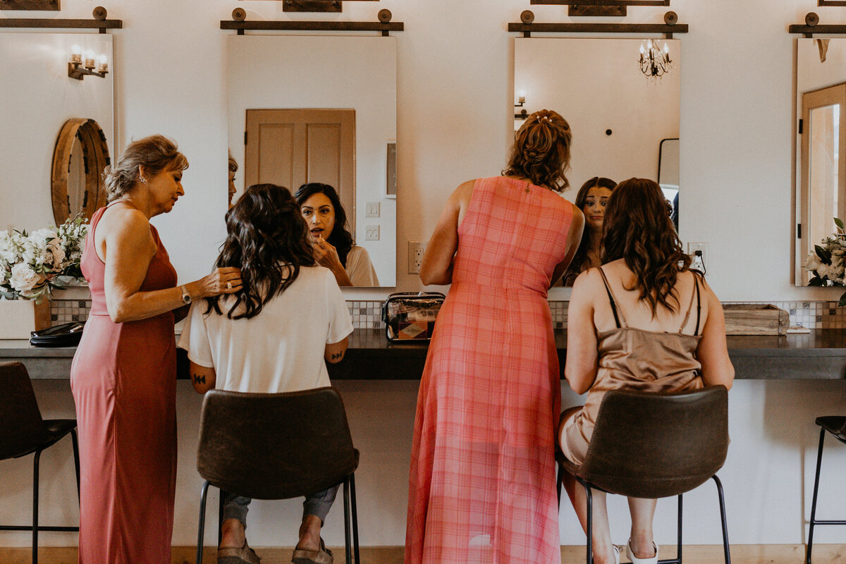 two brides getting ready for their wedding together with their moms