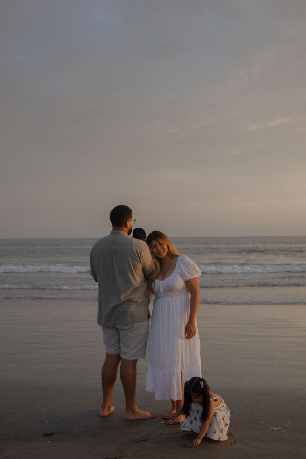 Family walking together on the beach at dusk