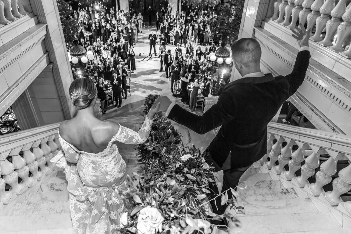 A black and white photo of a bride and groom holding hands