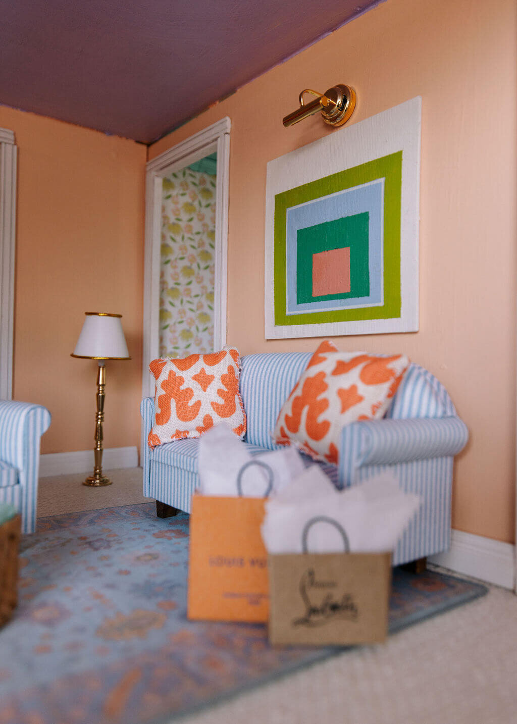 oyster creek studios petite palm beach dollhouse blue couch with orange pillows and shopping bags with gold floor lamp in living room
